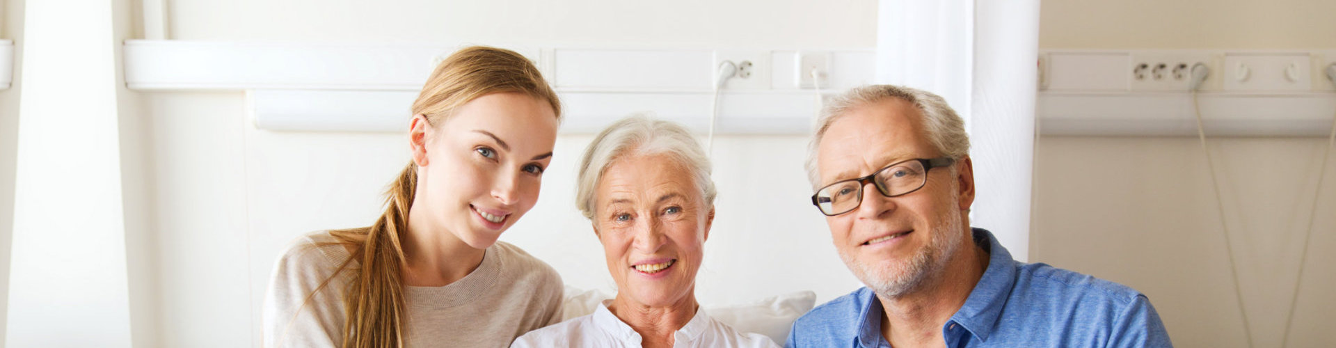 aide sitting and posing with elderly couple