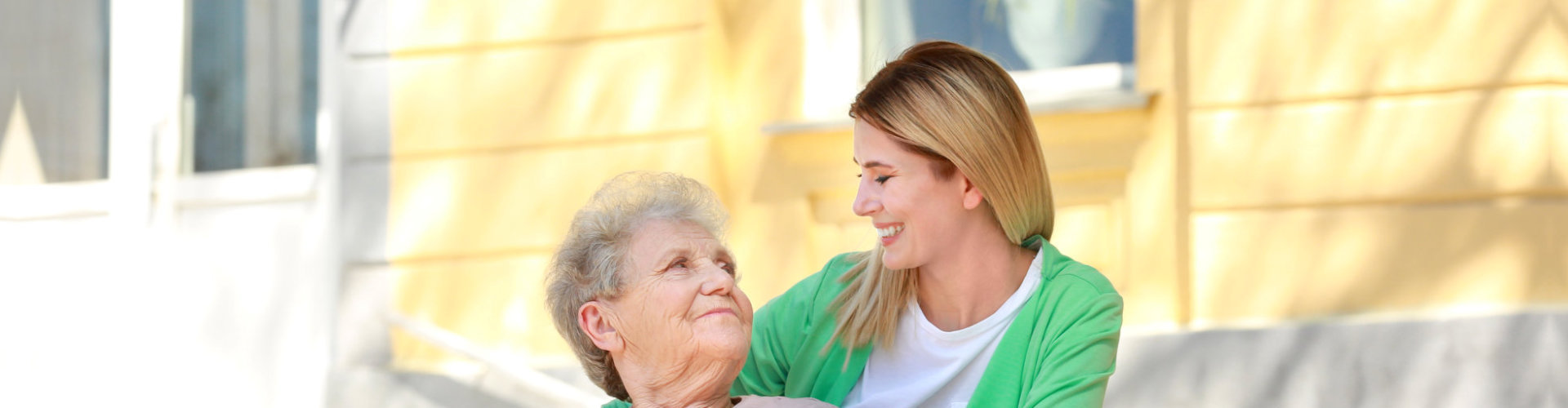 senior patient looking up at aide