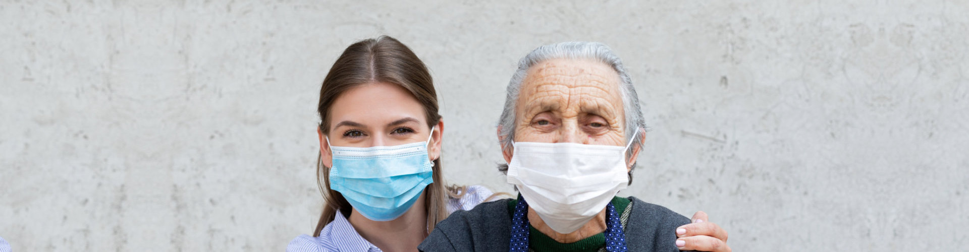 aide and senior patient wearing facemask