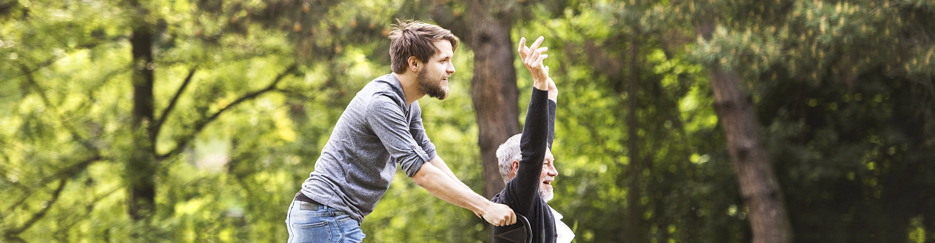 man pushing wheelchair of senior companion